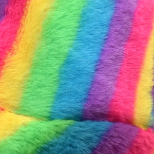 Macro shot of fluffy rainbow faux fur fabric showing soft colorful plush texture