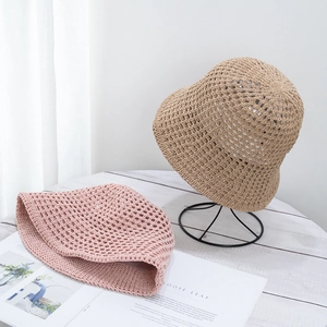 Detailed texture of hollow-out breathable straw bucket hats in khaki and pink colors