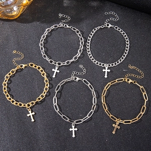 Detailed flat lay of cross pendant bracelets in gold and silver stainless steel styles