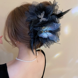 Detail of elegant black mesh hair claw with crystal butterflies and feather accents