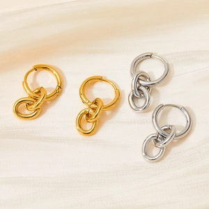 Gold and silver double link stainless steel hoop earrings on silk background