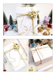 Detail of white gold-foil gift wrapping paper with matching gold ribbon and decorative bows