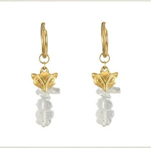 Detailed close-up of golden fox head earrings with irregular clear stone charms
