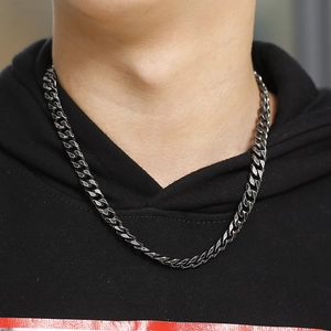 Close-up of men's stainless steel Cuban link necklace in vintage silver on a black hoodie