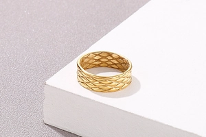 Macro shot of gold wide band ring with refined quilted fish scale engraved texture