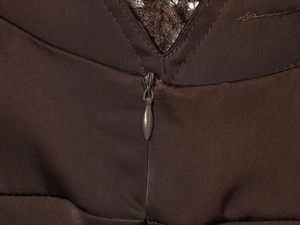 Détail de la fermeture éclair invisible et de la dentelle sur la robe en satin marron café