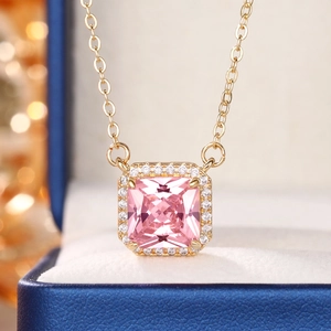 Macro shot of a square pink gemstone pendant necklace with halo stones in a gift box