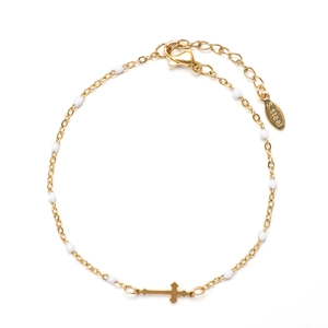 Detail of gold stainless steel bracelet with white beads and a small cross charm