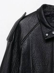 Detail der schwarzen Kieselleder-Textur und Schulterklappen an einer Motorradjacke
