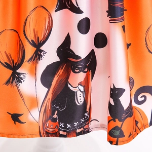 Detail view of Halloween girls pumpkin dress featuring witch and black cat festive prints