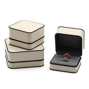 Premium beige leather jewelry gift box with black piping and gray velvet interior lining