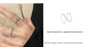 Detail of silver rings featuring open butterfly and heart zircon designs on fingers