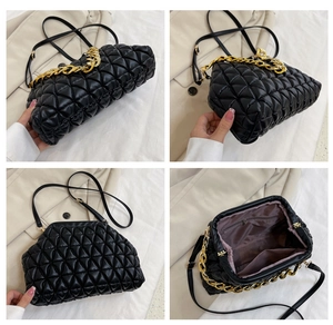 Close-up of black quilted shell bag showing gold chain strap and metal clasp closure