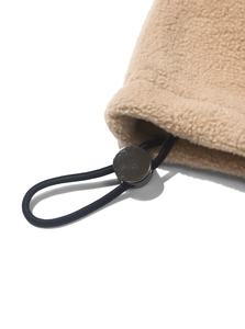 Close-up of beige sherpa fleece texture with black drawstring and metal stopper detail
