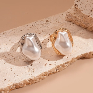 Baroque pearl rings with irregular gold and silver textured metal bands on stone