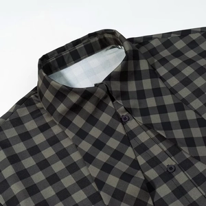 Detail of green and black plaid shirt collar showing sewing quality and buttons