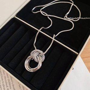 Detailed close-up of multilayer silver circles pendant on a sleek snake chain necklace
