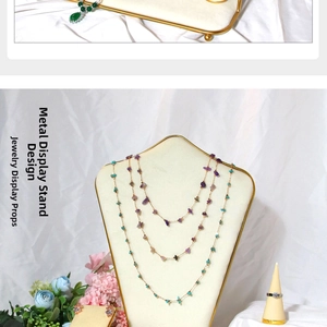 Macro shot of cream velvet jewelry stands with gold metal frames for rings and necklaces