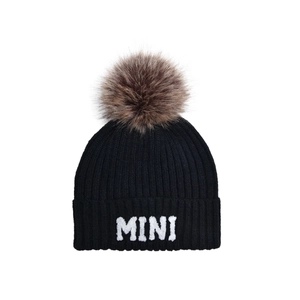 Close-up of black ribbed knit beanie with MINI embroidery and large faux fur pompom