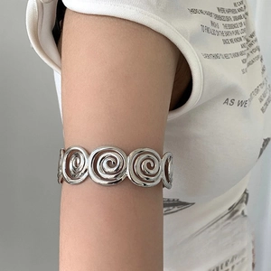Polished silver metal spiral arm cuff with geometric texture for upper arm placement