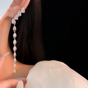 Close-up of model wearing silver tassel teardrop earrings with sparkling zircons