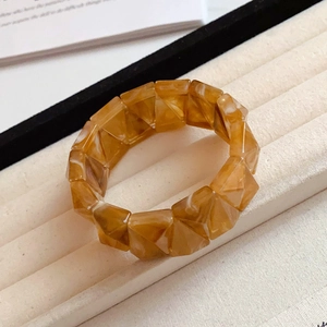 Macro shot of amber acrylic triangle stretch bracelet in a jewelry display box