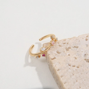 Golden branch-style open ring for women with colorful stones on a stone pedestal