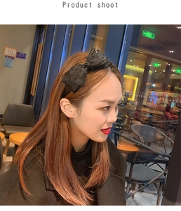 Side view of a woman wearing a black polka dot lace headband in a cozy cafe setting