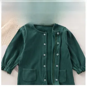 Dettaglio dei bottoni a pressione e trama in cotone a coste sulla tutina neonato verde scuro