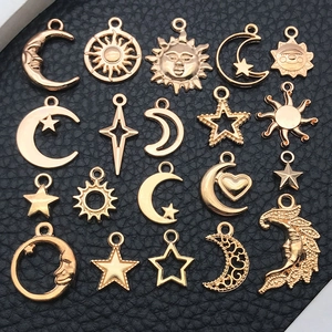 Dettaglio di ciondoli celesti dorati vintage con motivi di sole luna e stelle