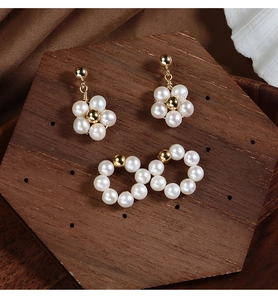 Macro shot of pearl earring set with floral and hoop designs on premium display
