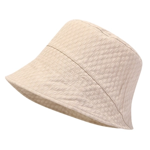 Close-up of beige sun hat featuring textured bubble fabric for foldable outdoor sun protection