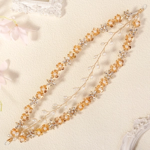 Macro detail of bridal hair vine with golden flowers, white pearls and sparkling crystals