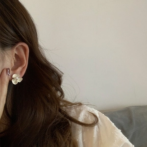 Élégantes boucles d'oreilles fleur blanche et perle pour femme portées par un mannequin