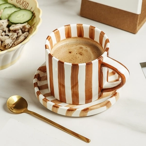 Japanese style hand-painted ceramic coffee mug with retro brown stripes on a marble table