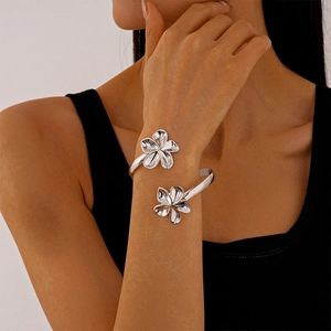 Détail d'un bracelet de bras argenté aux fleurs irrégulières sur le bras d'un mannequin