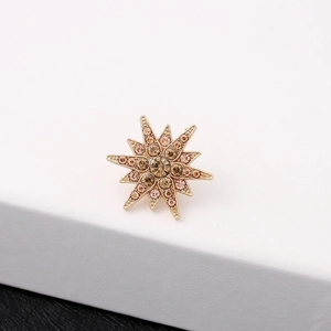 Elegant gold-tone star brooch featuring amber and yellow crystals for suits
