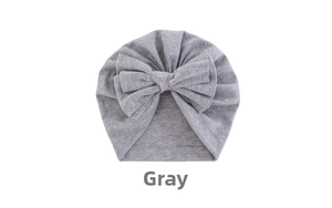 Detailed view of grey baby turban hat featuring a large double bow and pleated cotton fabric
