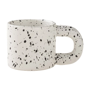 Minimalist white ceramic ink splash mug with a bold handle and black spots design