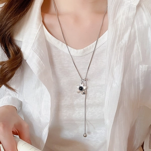 Detail of silver long necklace with floral pendant and adjustable slide bead on chain