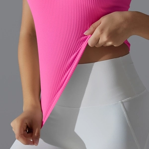Gros plan d'un débardeur de yoga rose montrant la texture côtelée du tissu élastique