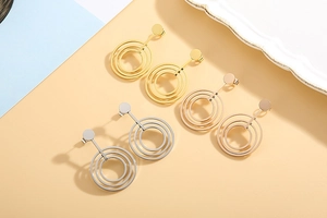 Detail view of geometric triple hoop earrings in gold, rose gold and silver finishes