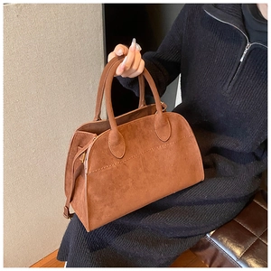 Brown faux suede tote bag detail held by model showing texture and medium size scale
