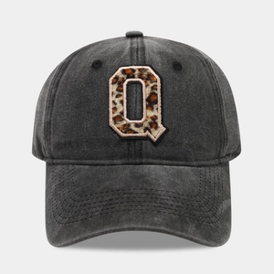 Detailed view of the leopard print Q embroidery on dark grey washed denim baseball cap