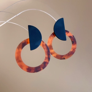 Detail of vintage resin hoop earrings featuring tortoiseshell pattern and geometric design
