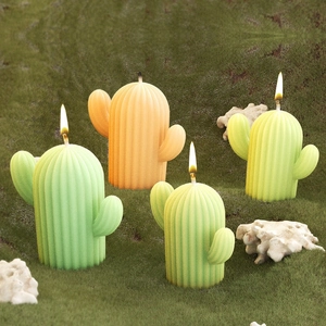 Dettaglio di candele a forma di cactus accese con texture realistiche su muschio