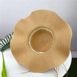 Close-up of wavy brim sun hat showing woven texture and interior sweatband detail