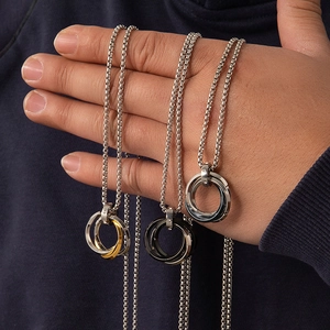 Primer plano de los collares hip hop con tres anillos entrelazados en oro, plata y negro