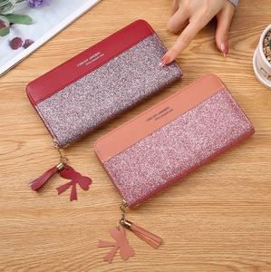 Detail of zip-around long wallets with glitter sequins and tassel bow pendants