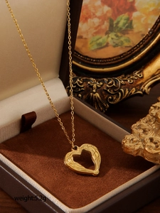 Close-up of golden heart pendant with wings inside a premium jewelry gift box